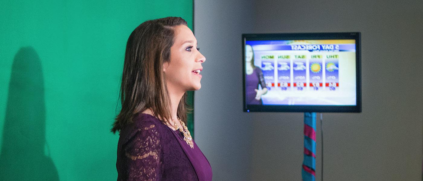 Broadcaster in front of green screen giving a weather update
